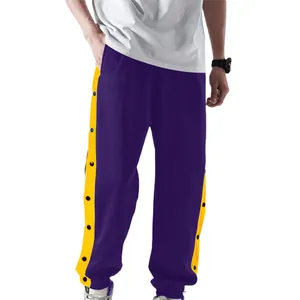 Detail van paarse heren sportbroek met gele drukknopen aan de zijstrepen voor mannen