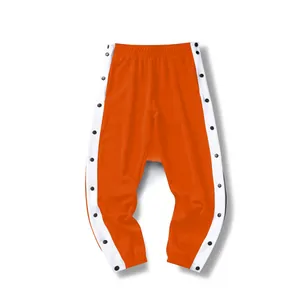 Gedetailleerde weergave van oranje sportbroek met witte zijstrepen en drukknopen.
