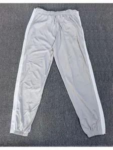 Gedetailleerd overzicht van grijze sportbroek voor heren met zijstrepen en elastische boorden.