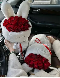 Close-up detail of plush rabbit ear flower packaging kit with red roses in a car