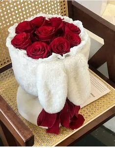 Detail view of plush rabbit ear hugging bucket with red roses on a rattan chair