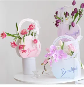 Elegantes cajas de regalo redondas para flores en tonos pastel con cintas y flores