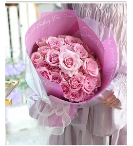Detail view of a lush pink rose bouquet wrapped in premium pink and clear paper
