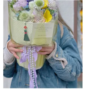 Elegante witte imitatieparelketting gebruikt als decoratief accent op een boeket bloemen