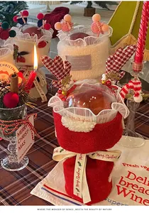 Vue détaillée de l'emballage de Noël en laine d'agneau rouge avec bois de renne et ruban.