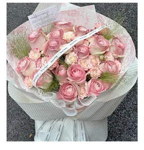 Vue détaillée d'un bouquet de roses roses luxuriant avec rubans et carte de vœux