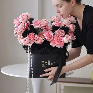Elegante imitatie parelketting over zwarte rozenbox voor romantische bruiloften.