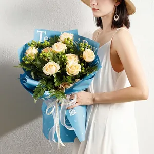 Papier d'emballage floral bleu ciel imperméable avec roses champagne pour enseignants