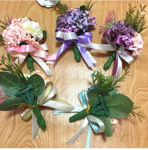 Detail view of wedding boutonnières with artificial hydrangeas and green plastic back clips