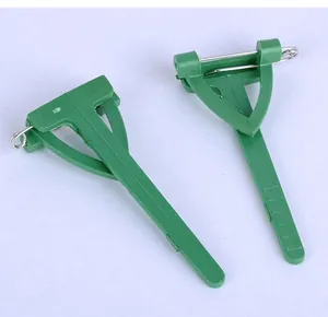 Detail view of green triangular plastic wedding corsage pins with safety mechanism.