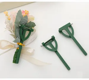 Detail view of green plastic triangular corsage clips for wedding boutonnieres.