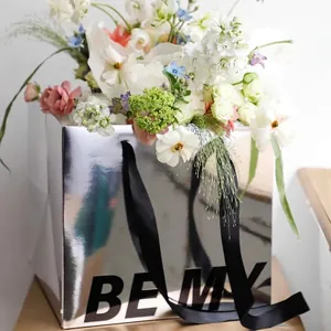Sacchetto regalo riflettente argento per fiori con nastro nero e scritta BE MY
