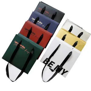 Sacchetti regalo minimalisti in carta colorata con manici in nastro nero per fiori e regali