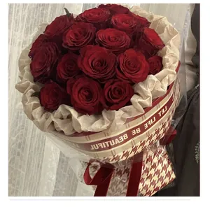 Elegante bouquet di rose rosse avvolto in carta regalo impermeabile pied-de-poule