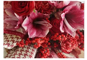 Primo piano di un bouquet rosso avvolto in carta di lusso impermeabile pied-de-poule