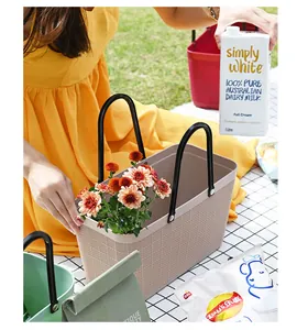 Close-up of beige waterproof plastic picnic basket with woven mesh texture and flowers.