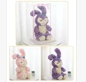 Vue détaillée des poupées lapin en pétales de rose dans un emballage cadeau rose et violet