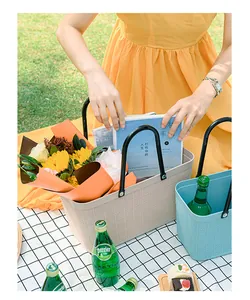 Detailed view of grid-textured waterproof plastic picnic basket with flowers and books.