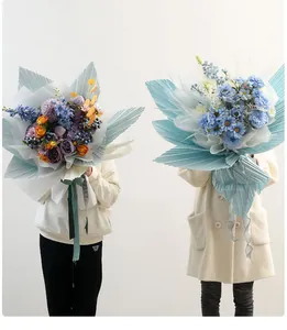 Dettaglio della trama plissettata sulla carta da regalo per fiori azzurra stile coniglio.