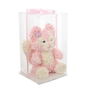Poupée renard en pétales de rose rose et blanc dans une boîte cadeau transparente