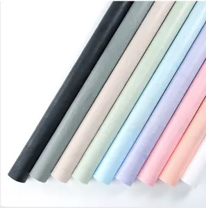 Vue détaillée de rouleaux de papier cadeau fleur guimauve multicolores à texture mate douce.