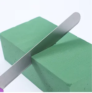 Dettaglio di coltello in acciaio inox per schiuma floreale che taglia spugna verde