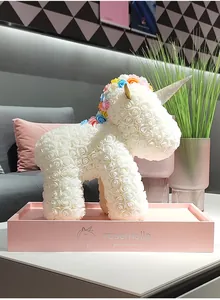Detalle exquisito de un unicornio de rosas de espuma PE blancas en una base de caja de regalo