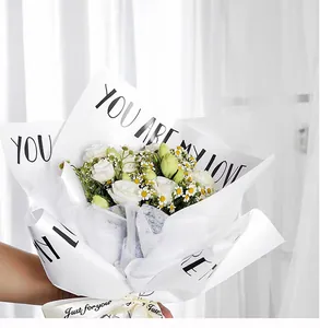 Close-up of waterproof pearlescent flower wrapping paper with black English text
