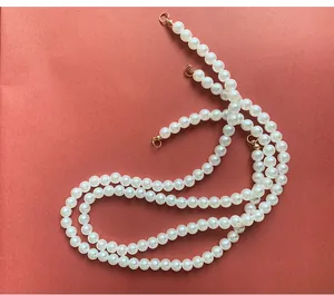 Nahaufnahme einer langen weißen Kunstperlenkette für die DIY-Blumenstrauß-Dekoration zu Hause