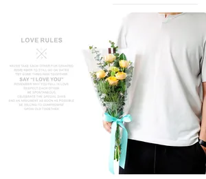 Detail view of transparent 'Love Rules' flower bouquet packaging bag with yellow roses