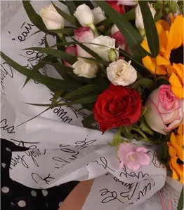 Nahaufnahme von Blumenwickelpapier mit elegantem schwarzem Schreibdruck für Floristen