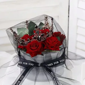 Vintage rose gold crown with black gems on red roses in black tulle gift wrap.