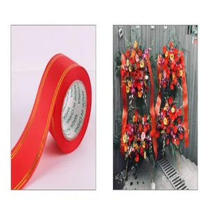 Detail of red ribbon with gold stripes used in celebratory floral wreaths