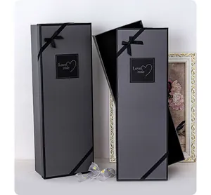 Detail of two long rectangular grey gift boxes with elegant black ribbons and heart logo
