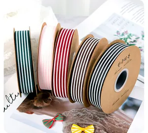 Detail view of multi-colored vertical striped grosgrain ribbon rolls on kraft spools