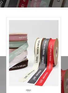 Close-up of textured polyester ribbon with 'LOVE! none is not you' print for floral packaging