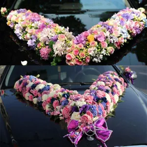 Close-up of V-shaped floral decoration on wedding car hood with colorful flowers.