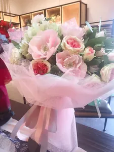 Nahaufnahme von hellrosa gepunktetem Netzgewebe für professionelle Blumenstraußverpackungen.
