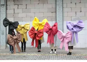 Persone con fiocchi giganti colorati in tessuto fai-da-te per decorazioni da fiorista.