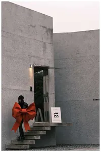 Grande kit fiocco rosso fai-da-te tenuto da una modella in un contesto architettonico