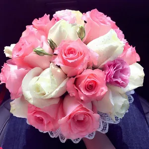 Elegant bridal bouquet featuring pink and white roses with delicate white lace holder