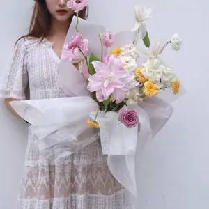 Papier d'emballage en coton blanc élégant pour grands bouquets de fleurs portés.