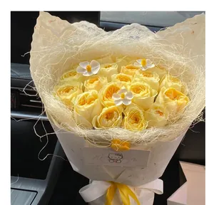 Gros plan d'un bouquet de roses jaunes avec emballage en fibre de sisal crème