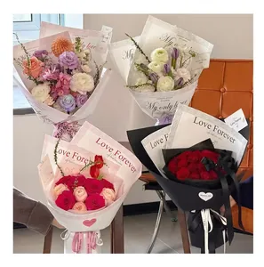 Vista detallada de hermosos ramos envueltos en papel de encaje con 'Love Forever'.