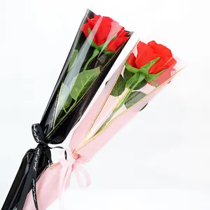 Due rose di sapone rosse artificiali in eleganti sacchetti regalo neri e rosa