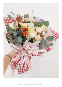 Close-up of red gingham and pink pearlescent wrapping paper on a flower bouquet