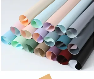 Detailed macro view showing a collection of multi-colored double-sided flower wrapping paper rolls