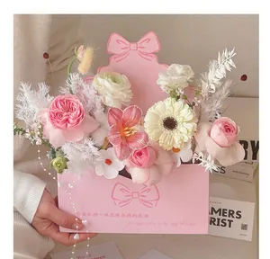 Close-up of pink envelope flower box with bow and romantic message for DIY floral gifts