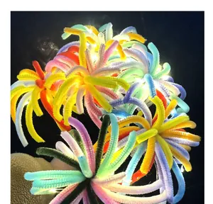 Close-up of vibrant DIY pipe cleaner fireworks craft kit featuring warm LED string lights