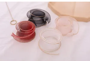 Detail view of translucent gold-edged fishtail yarn ribbons in various elegant colors